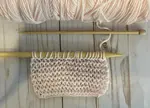 The knit condo stitch shown on needles, worked in pink