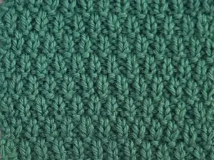 A swatch knit in green 100% wool of the Swift Stitch