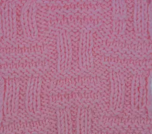 A swatch of the double basket stitch worked in pink yarn.