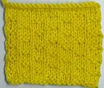 Right side showing of a knitted  swatch of the double fleck stitch worked in yellow yarn.