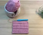 The extended half double crochet stitch pattern worked in pink wool