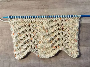 A swatch of feathers and fan knit stitch pattern worked in cotton yarn