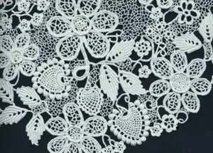 A sample of Irish crochet worked in white cotton on a black background