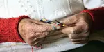 An older person is crocheting