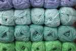 Stacks of acrylic yarn skeins in shades of blue and green