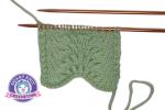 Feather and Fan knit stitch pattern swatch in green yarn