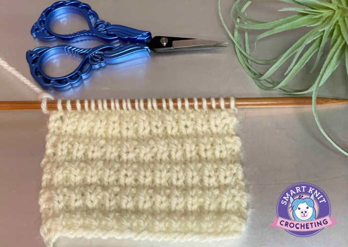 The interrupted knit stitch patter worked in a light colored wool yarn