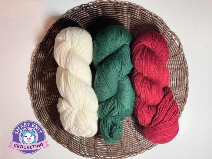 Three hanks of 100% wool are shown in cream, red and green