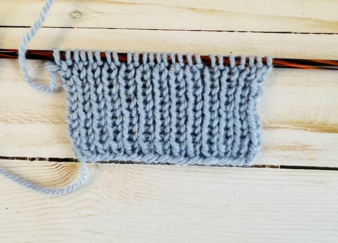 1 x 1 Ribbing A swatch of 1 x 1 ribbing worked in blue yarn, on needles