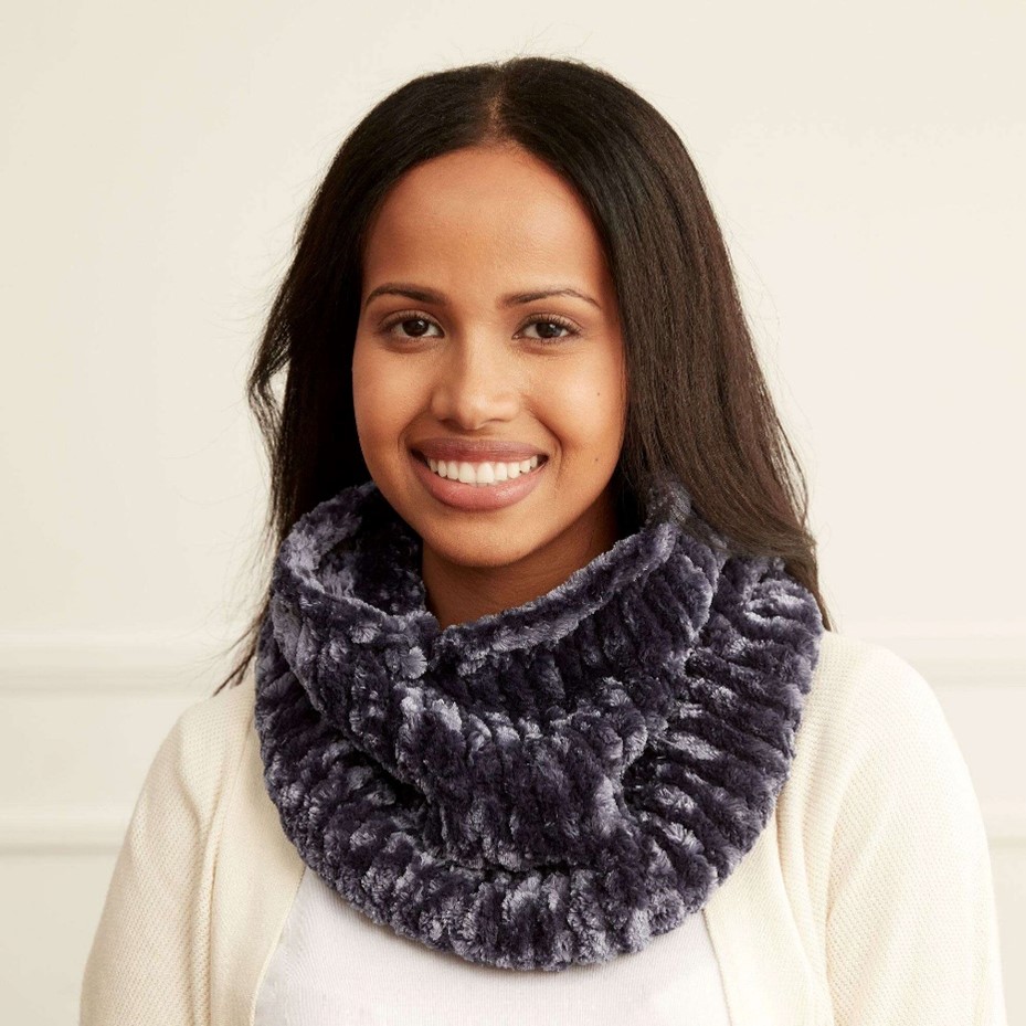 A young woman is modeling a Bernat Knit Cowl 