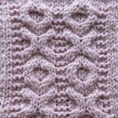 A cable swatch worked in pink showing the xoxo cable pattern