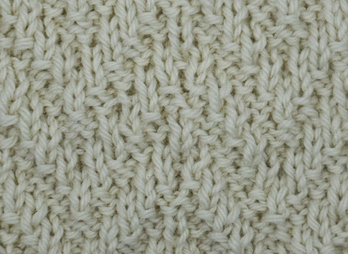 Chevron rib knit stitch pattern worked in white yarn.