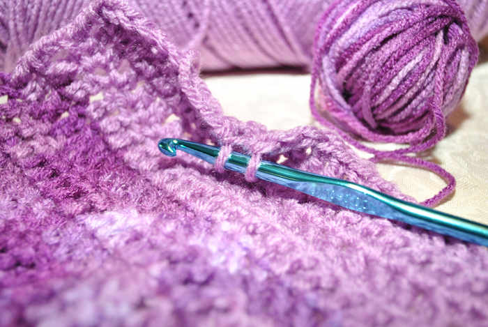 A sample of crochet showing hook and varigated yarn. A sample of crochet showing hook and varigated yarn.