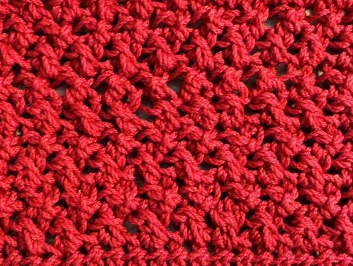 Crossed half-double crochet worked in red 100% cotton, showing close up view of stitches Crossed half-double crochet worked in red 100% cotton, showing close up view of stitches