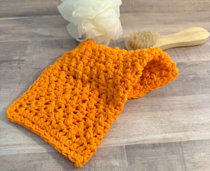 An orange 100% cotton washcloth/dishcloth worked in the crossed half-double crochet stitch. An orange 100% cotton washcloth/dishcloth worked in the crossed half-double crochet stitch.