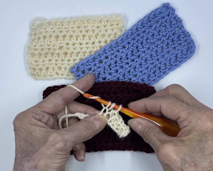 Furls ergonomic crochet hooks shown with three crocheted swatches worked with the hook