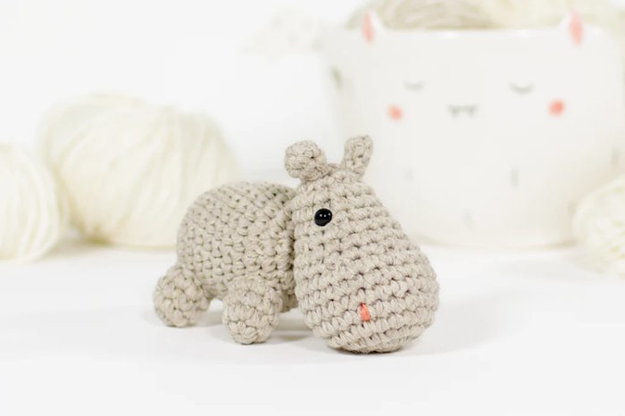 A small hippo toy crocheted in beige colored yarn
