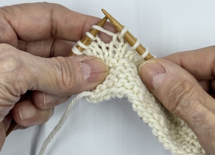 A swatch on the needles demonstrating how to make the make-one left increase