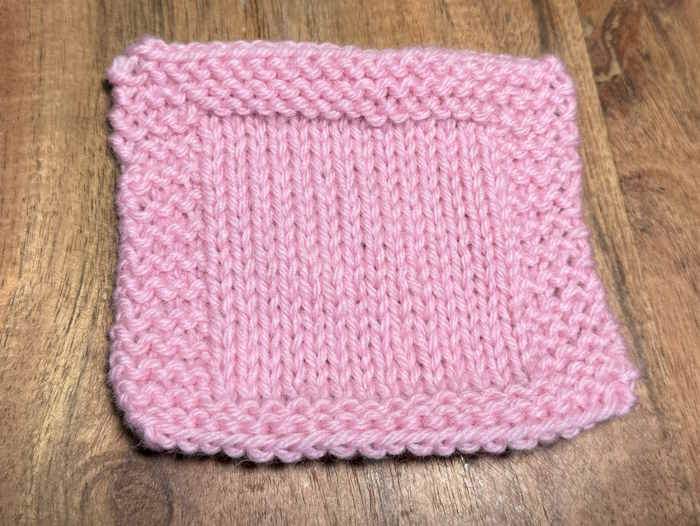 A knitted swatch worked in Paton's Classic Wool Worsted yarn in colorways pink A knitted swatch worked in Paton's Classic Wool Worsted yarn in colorways pink