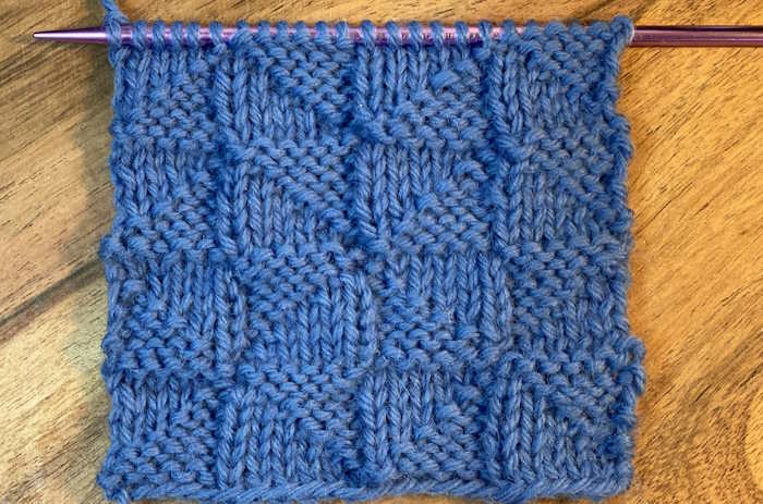 The right side showing of the pythagorean knit stitch pattern worked in 100% blue wool yarn