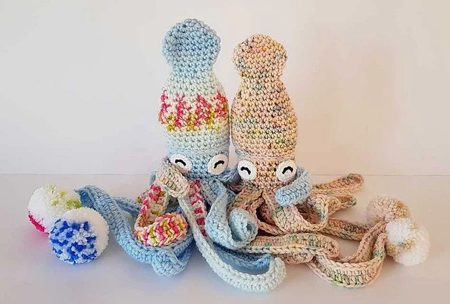 Two toy squids are crocheted in colorful yarn