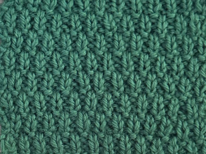 A swatch knit in green 100% wool of the Swift Stitch