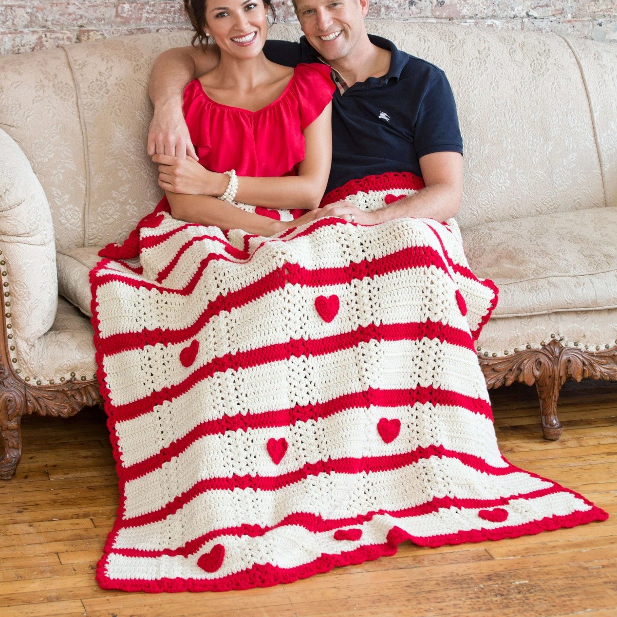 A throw worked in red and white yarn with hearts on it A throw worked in red and white yarn with hearts on it