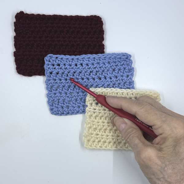 The Tulip Ergonomic crochet hook shown with swatches
