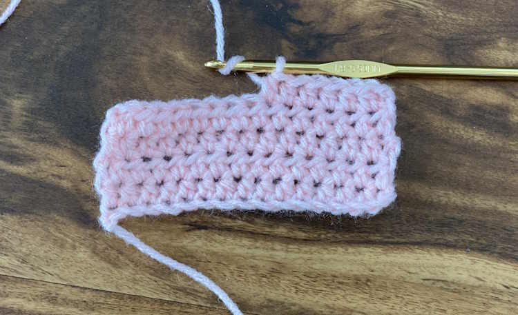A crochet swatch showing the yarn wrapped around the hook, yarn over