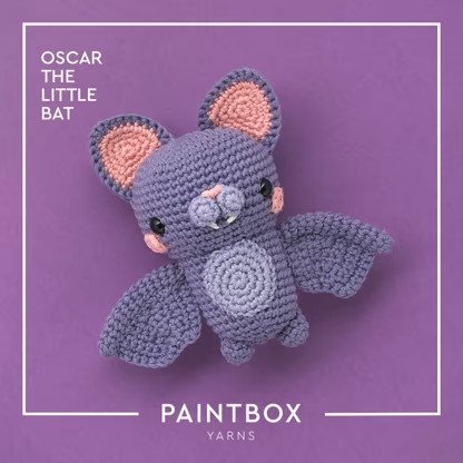 A bat toy crocheted with gray and pink yarn