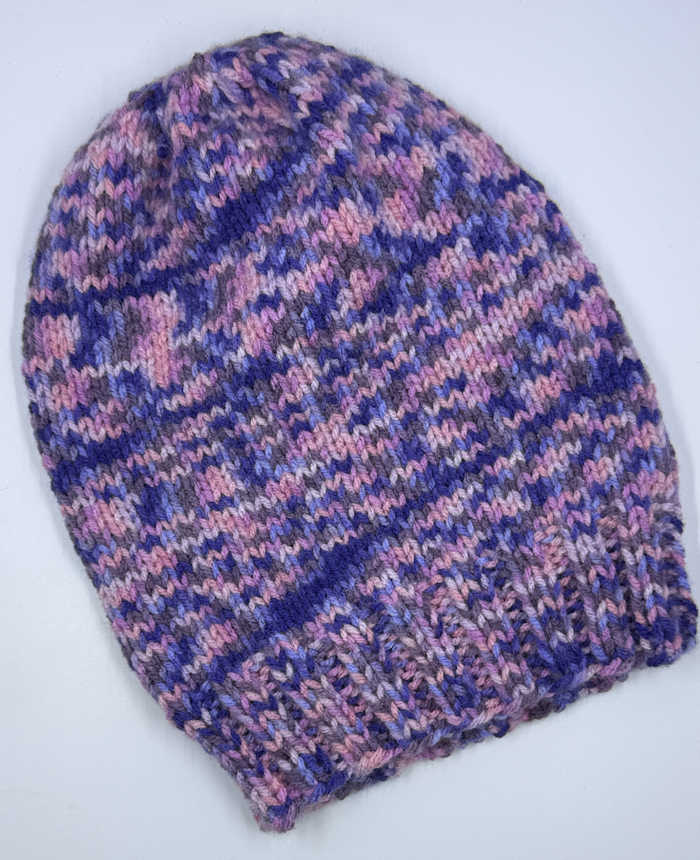 A beannie worked in the round with purple varigated yarn