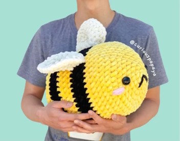 A giant bee toy crocheted in yellow and black yarn