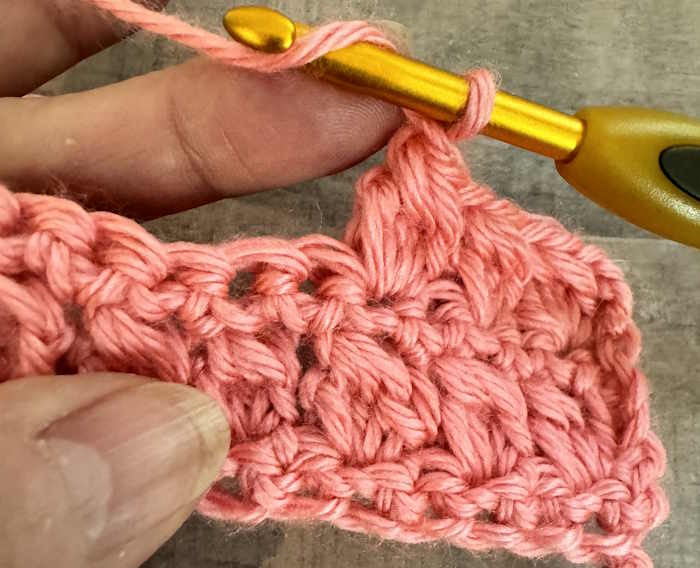 Step-by-step instructions for making the crochet bobble stitch:  step one