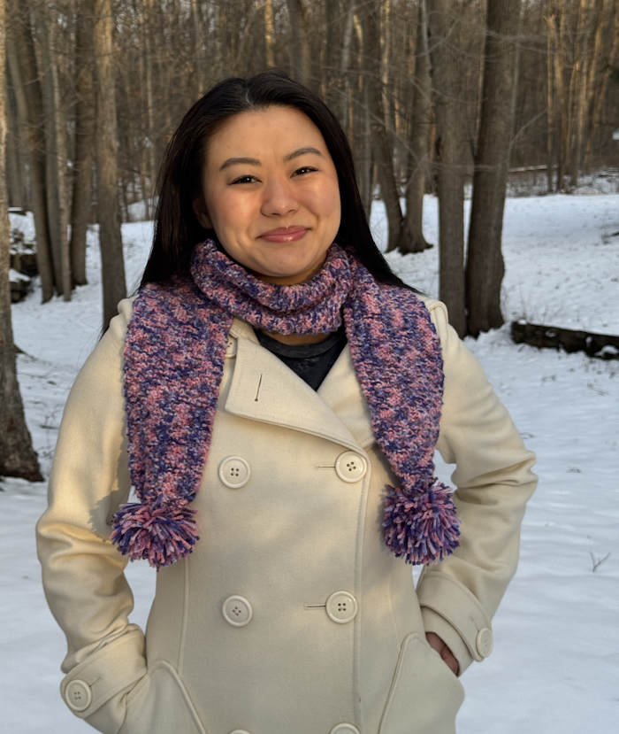 A box stitch scarf worked in a varigated yarn modeled by a young woman