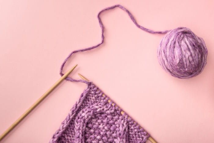 A swatch of a cable pattern still on the needles