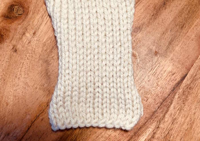 A knitted swatch is show with the cast on edge and the first row is knitted