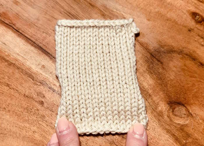 A knitted swatch showing the cast on and bind off edge.  The first row is purled.