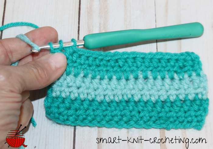 Changing colors at the end of a crochet row by adding a loop of new yarn and continuing to work.