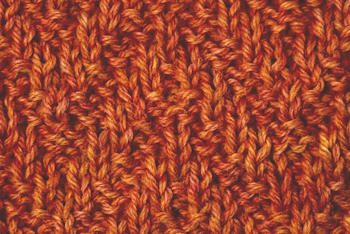 Thumbnail image of the chevron rib knit stitch swatch worked in orange yarn.