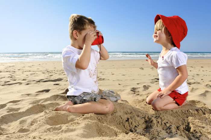 A young boy with a camera is taking a photograph