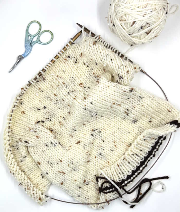 A KnitPro interchangeable needle set is being used to knit a sweater flat.