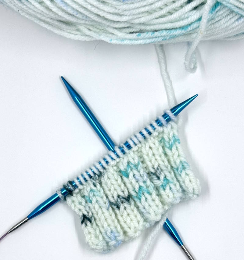 A set of Yarniss Interchangeable needles being used to knit a swatch of 2 x 2 ribbing.