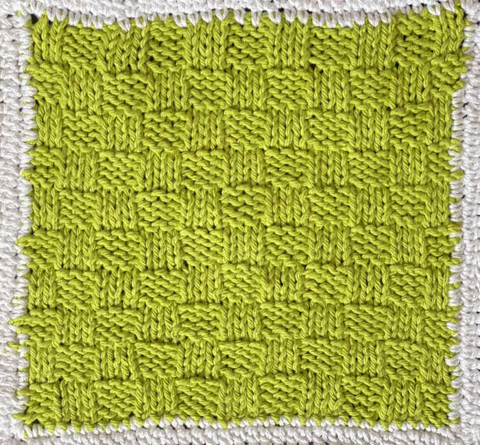 A washcloth made with the close check knit pattern and a crocheted border