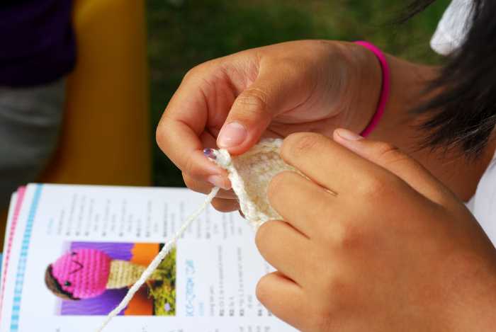 Shown is a crochet book with a person crocheting.