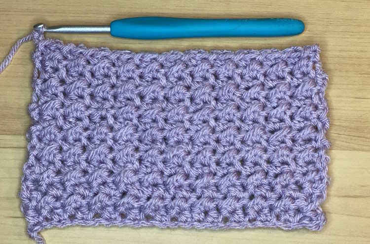 A sample of crochet crunch stitch worked in light purple acrylic yarn