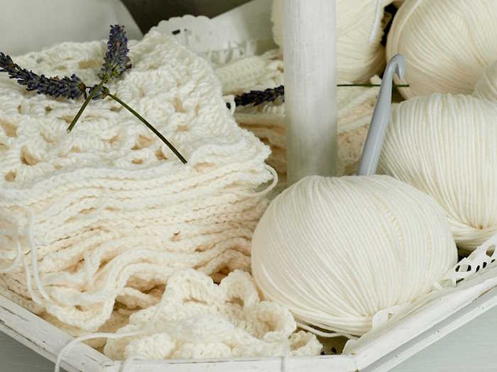 White yarn used to make a stack of white crochet motifs White yarn used to make a stack of white crochet motifs