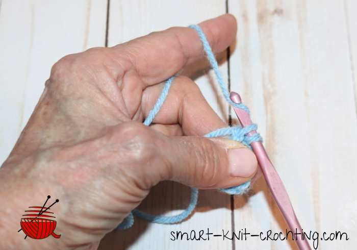 Working a crochet slip stitch with blue yarn