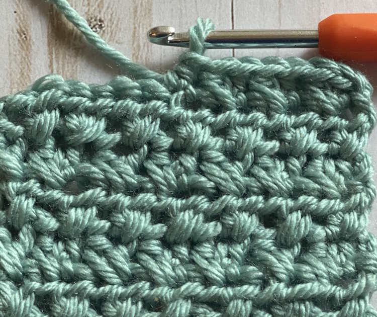 A swatch worked in teal yarn of the crossed half double crochet stitch.