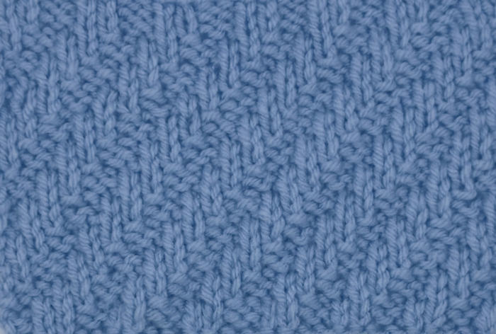 Right side showing of a swatch of the diagonal rib stitch worked in blue