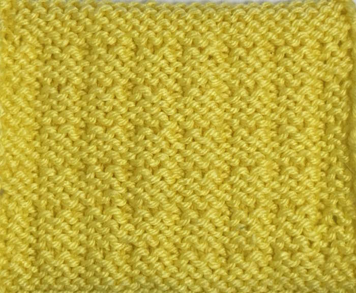 A swatch showing the wrong side of the double alternate andalou stitch worked in yellow yarn